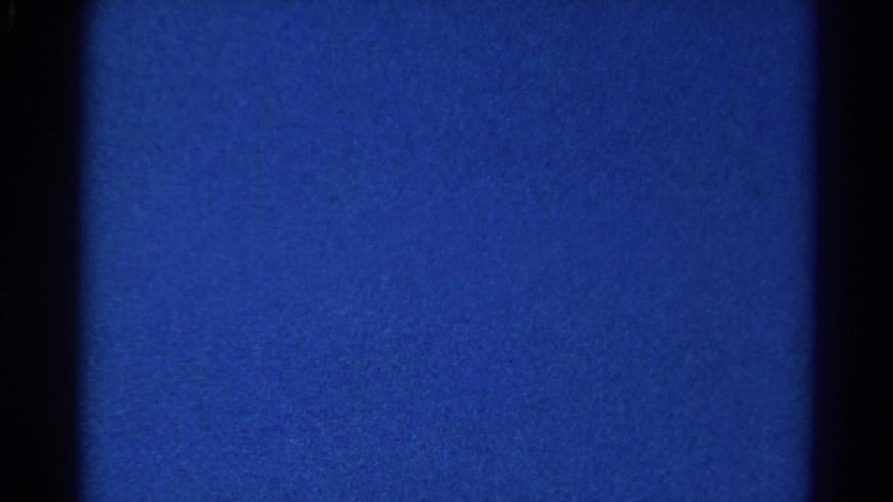 Steady blue 8mm frame from the 1966 Danville clip, showing dark gate edges, grain, and slight tonal variation.