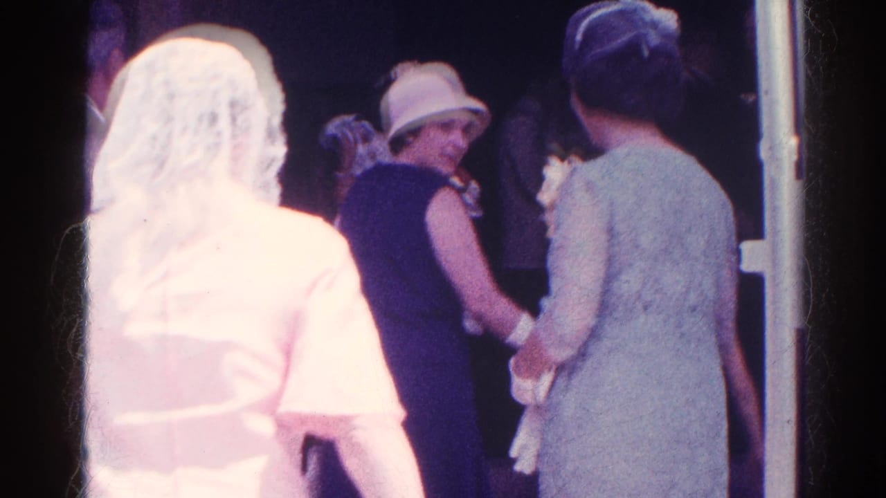Bride in a white veil approaches guests at a church entrance during the 1966 Danville wedding scene.