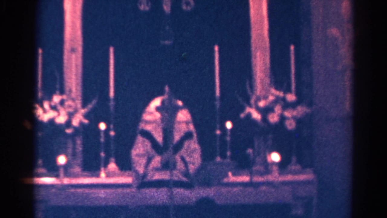 Dim church altar with candles, flowers, and a robed clergy figure.