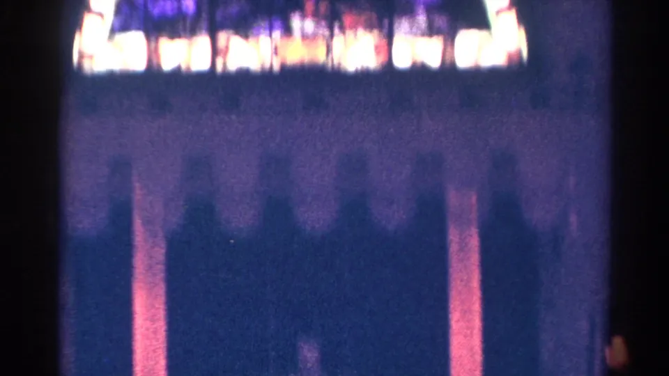 1966 Danville, Illinois 8mm frame with a dim interior wall and a blurred band of stained glass above.