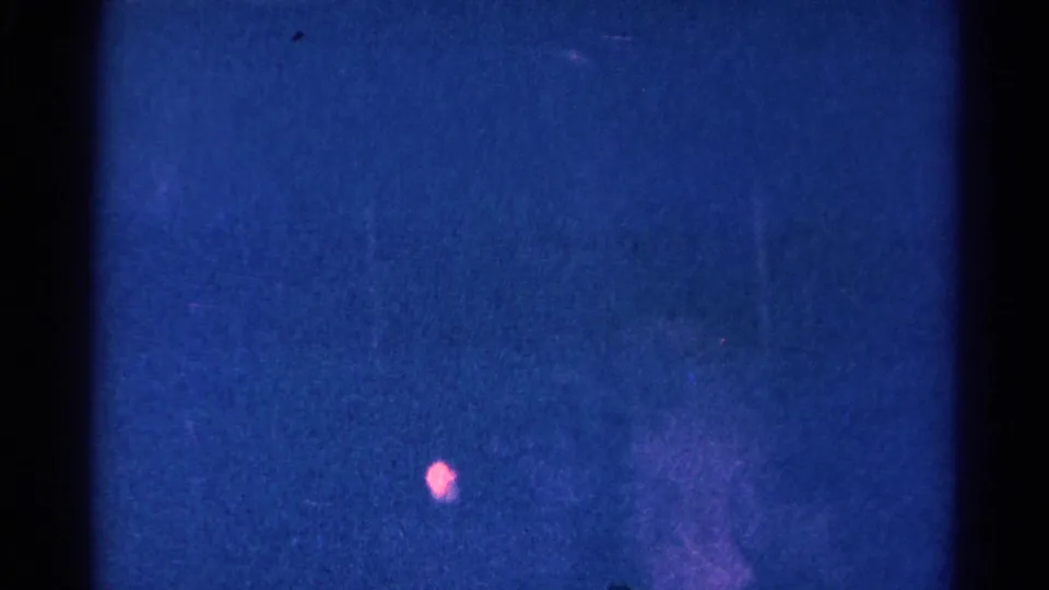 Low-light 8mm frame with blue grain and a small pink artifact, likely from the same 1966 Danville church home movie.