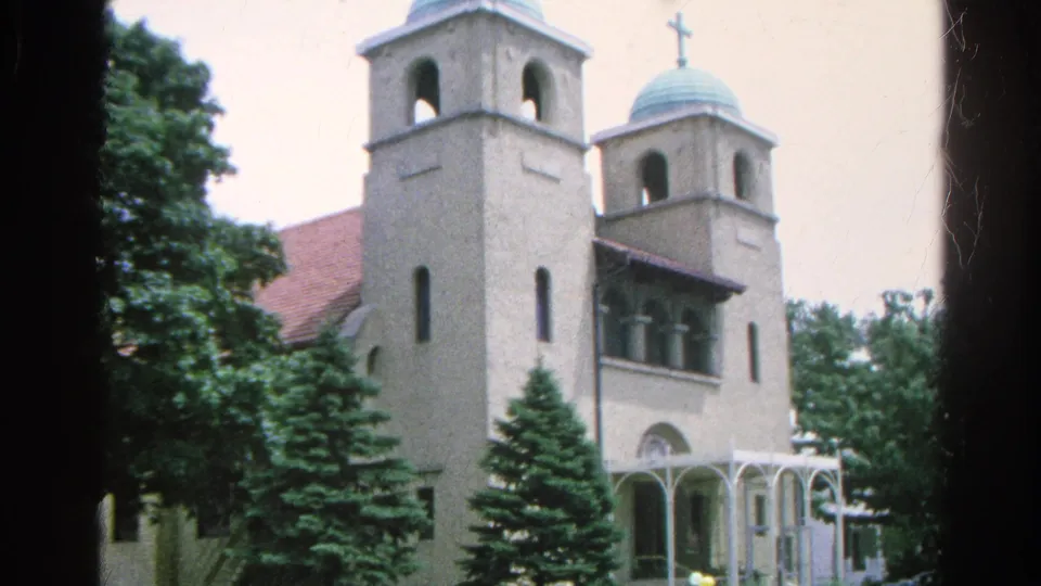 A church exterior appears in the final 1966 Danville, Illinois frame, showing twin towers, domed roofs, a cross, arched entry, and trees.