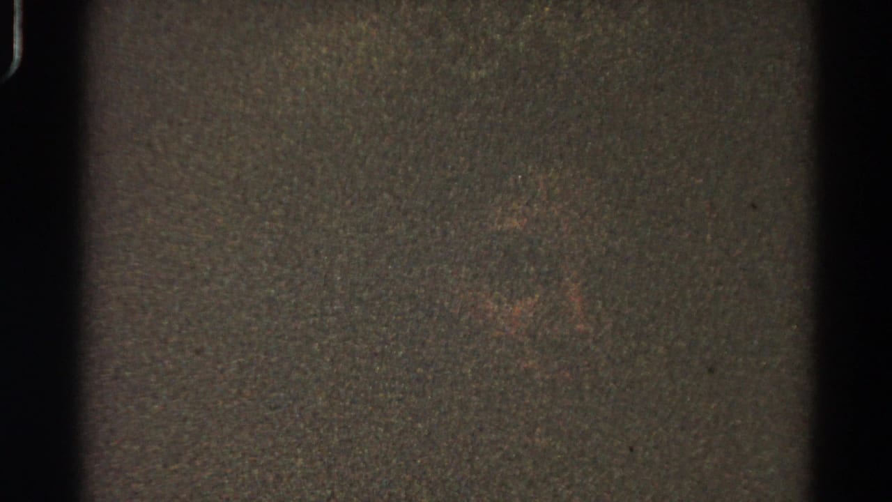 1966 Danville, Illinois 8mm home-movie frame showing darkness, heavy grain, gate edges, and a faint indistinct central mark.