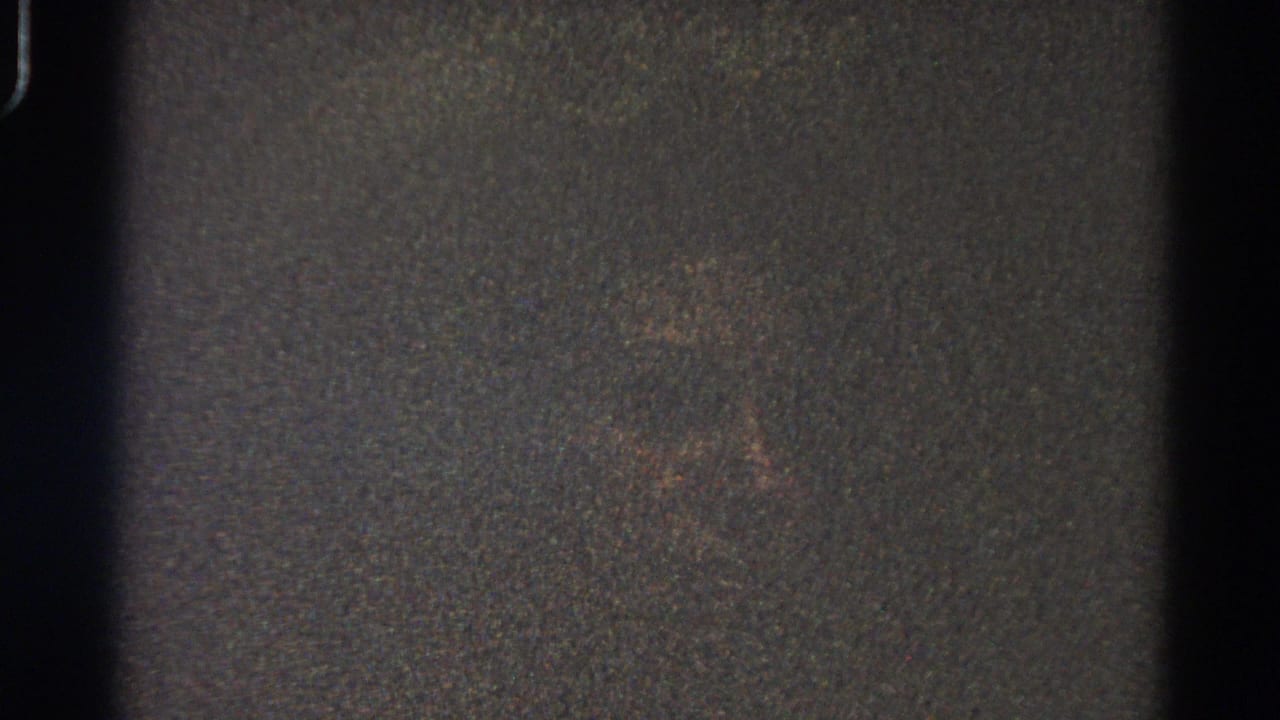 1966 Danville, Illinois 8mm frame with heavy grain, low light, a faint reddish mark, and visible film border artifacts.