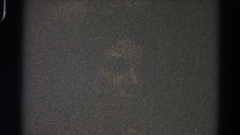 1966 Danville, Illinois home-movie frame showing dark exposure, visible film borders, grain, and faint brownish marks.