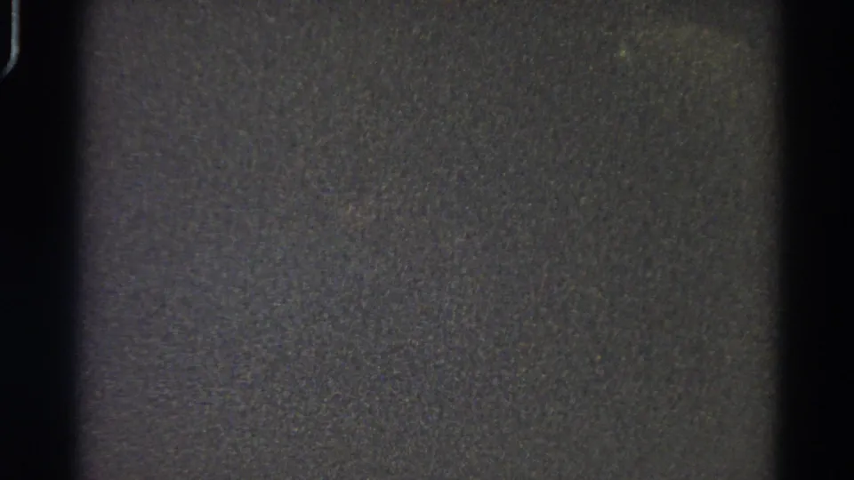 Dark, underexposed 1966 Danville 8mm frame with heavy grain, black film borders, and no visible people or objects.