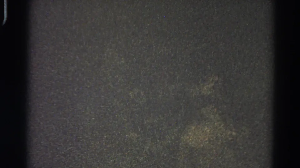 Low-exposure 8mm frame from the 1966 Danville home-movie reel, showing grain, gate shadow, and no discernible subject matter.