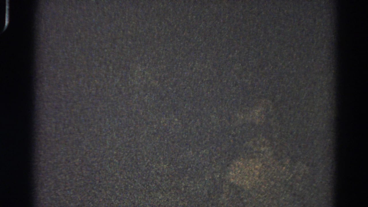 Dark grainy frame with central black divider and faint mottled texture.