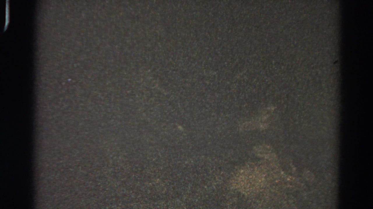 Dim 1966 Danville 8mm frame with a black edge band, speckled grain, and faint yellow-green exposure patches; no people are visible.