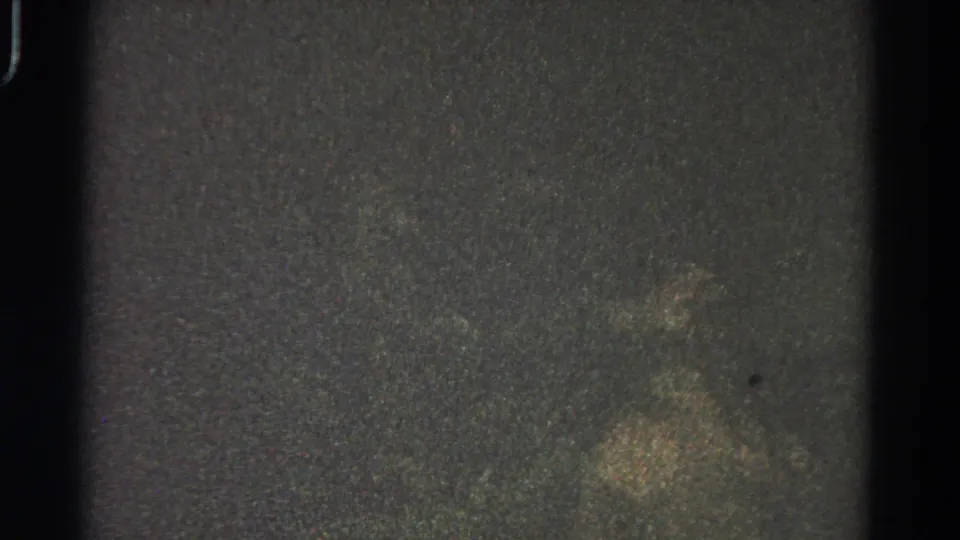 Heavily obscured 1966 8mm frame from Danville metadata, with dark borders, speckled grain, and faint cloudy exposure but no identifiable figures.