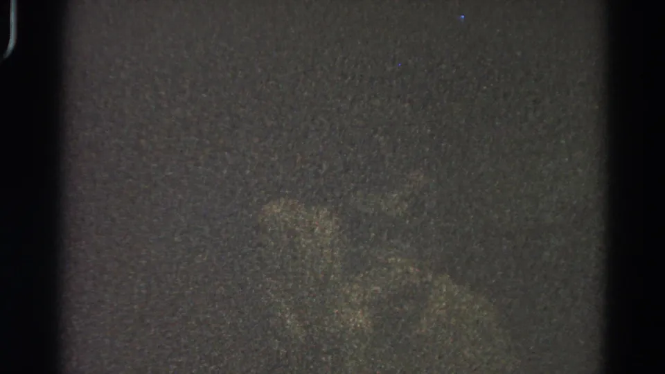 Dark 1966 Danville 8mm frame showing mottled exposure, a vertical edge shadow, visible grain, and no readable people or setting.