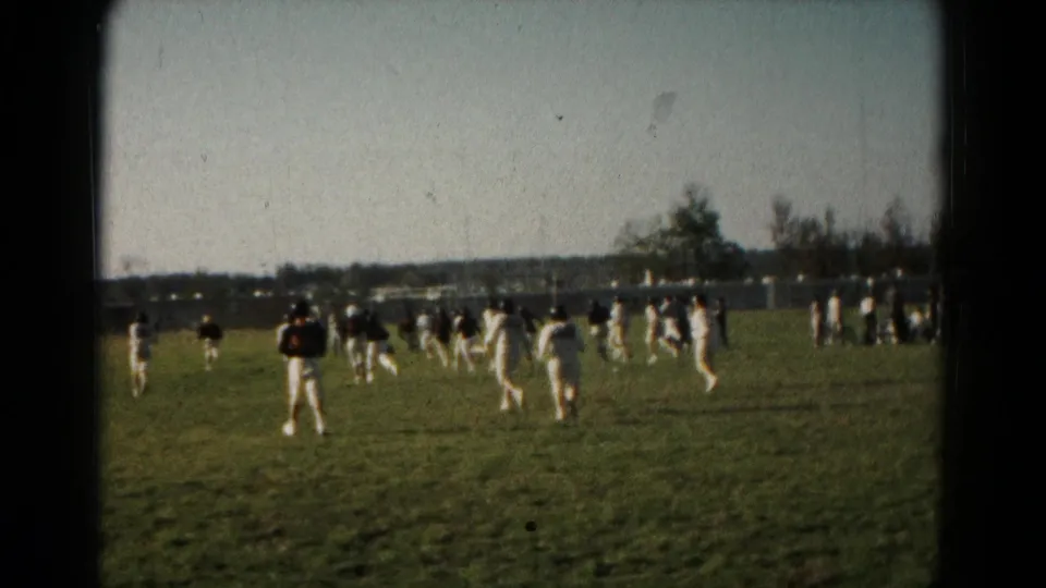 Sideline 8mm frame from Hagerstown, Maryland, showing clustered field-sport players during play in 1966.
