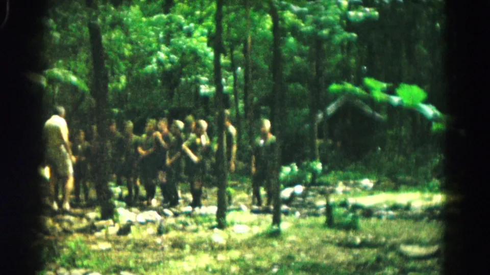 A brighter 1966 8mm frame shows adults gathered in a wooded opening near Hagerstown, with rocks and greenery around them.