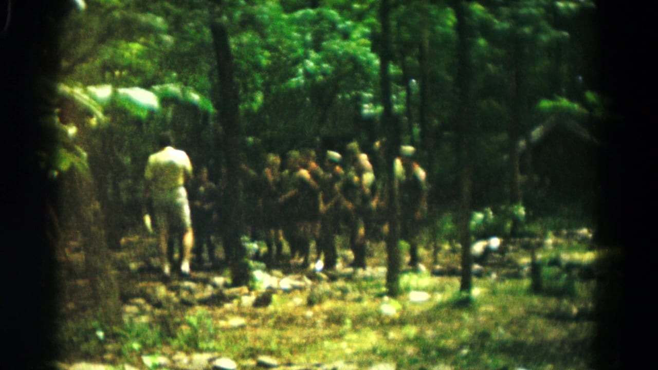 A distant 1966 Hagerstown camp scene with an adult appearing to lead boys in a shaded forest setting.
