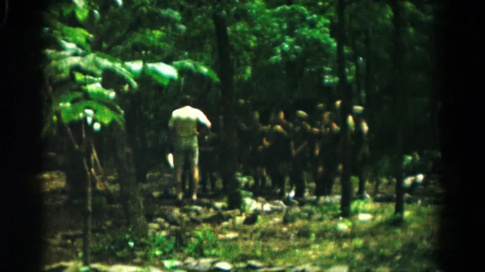 Soft 8mm footage shows a youth group in a wooded Hagerstown setting, with an adult positioned as if giving instructions.