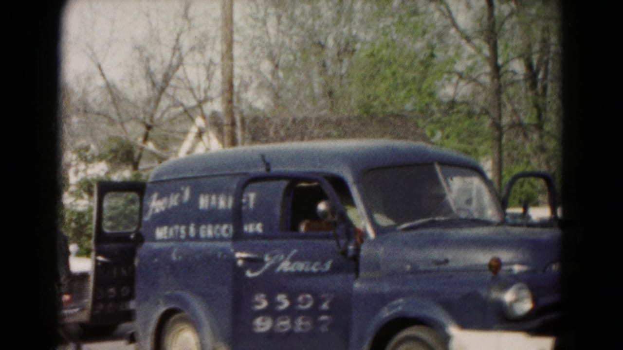 Closer 1966 Hagerstown view of the blue Frank's Market Meats and Groceries van with side lettering and open doors in a lot.