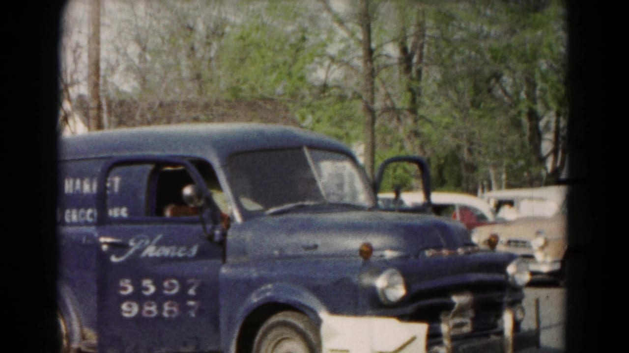 1966 Hagerstown frame showing the front and side of the blue Frank's Market van with an open door and cars behind it.