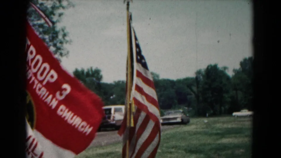 Red Troop 3 First Presbyterian Church flag appears beside American flags and mid-century cars in Maryland camp footage.