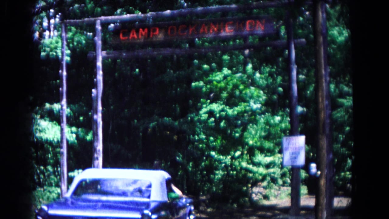 A blue vintage convertible approaches the Camp Ockanickon entrance in wooded Hagerstown, Maryland, in 1966 home-movie footage.