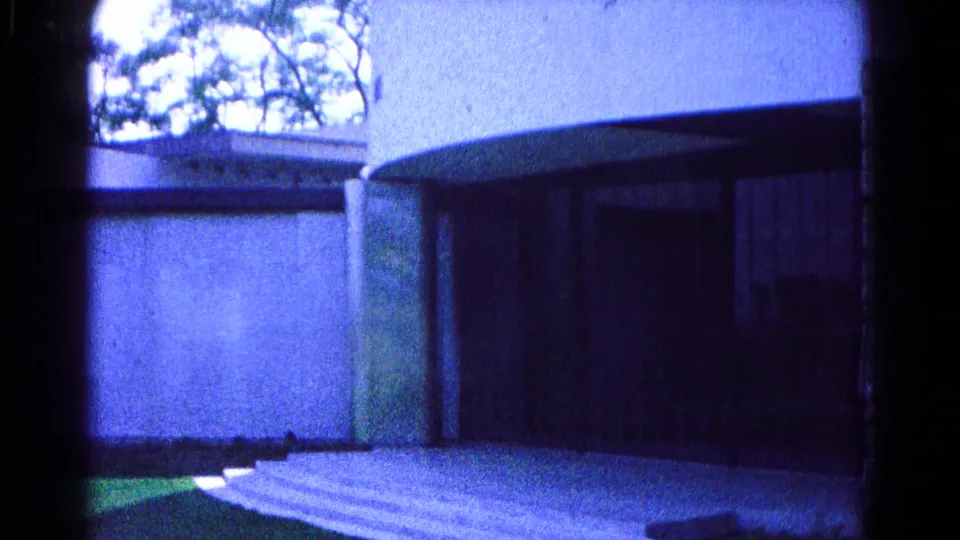 Blue-toned 1966 Hagerstown frame of a curved modernist building exterior, steps, lawn, and trees overhead.