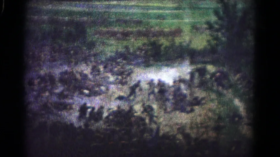 1966 Hagerstown 8mm frame with dark foreground figures, pale smoke, and a crowded field beyond.