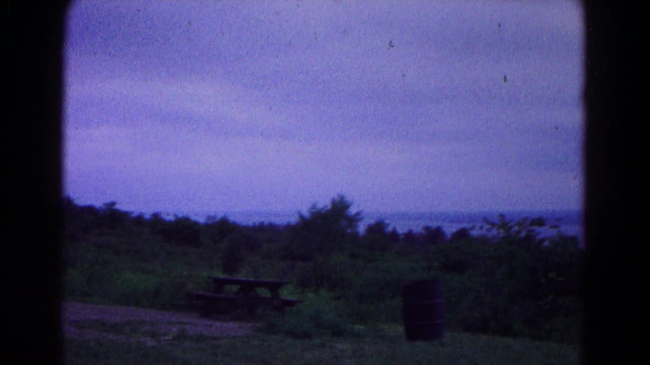 1966 Hagerstown-area home-movie frame showing a rural overlook with picnic table, barrel, trees, and distant horizon.