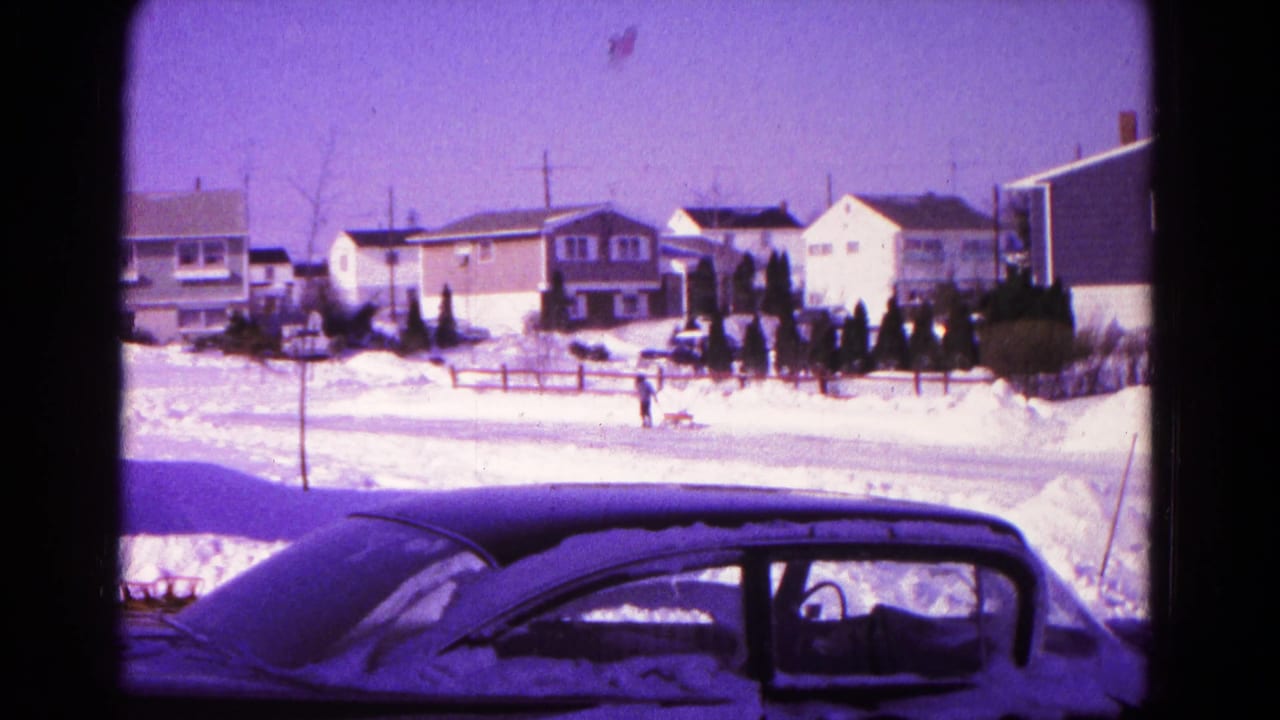 1966 Hagerstown residential winter frame with a person and dog moving across a plowed, snow-lined street.
