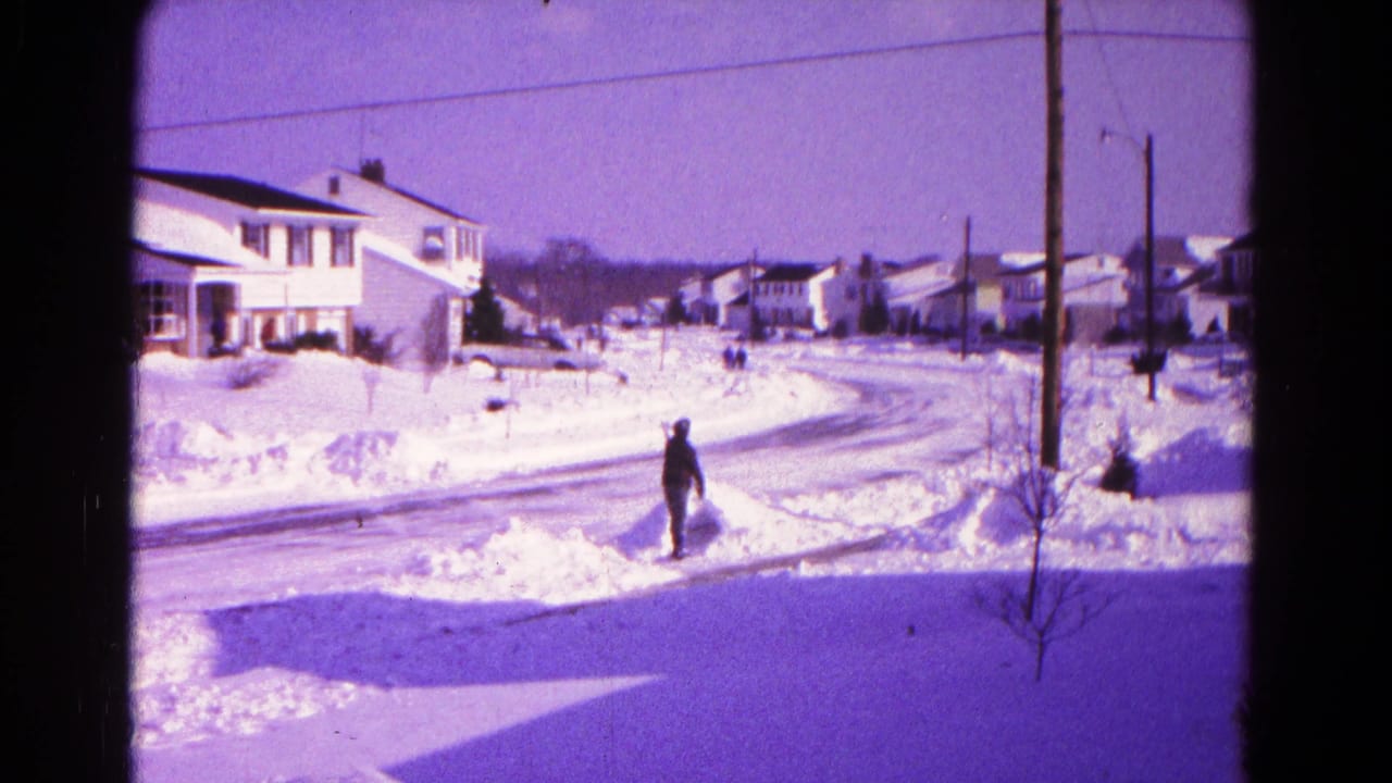 Wide 1966 Hagerstown residential winter view with a person standing near deep snow beside a suburban street.