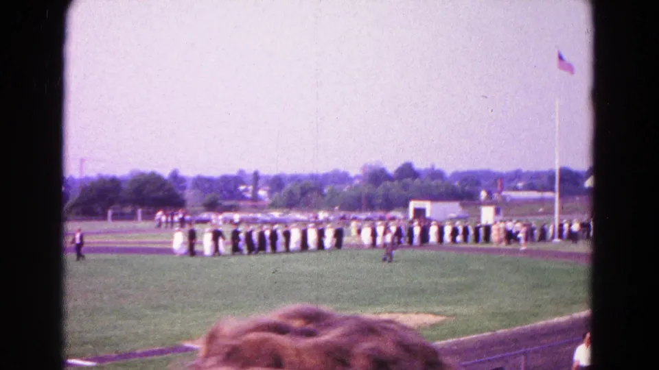 Wide 1966 Hagerstown graduation shot showing a long row of graduates on a field beside a running track.