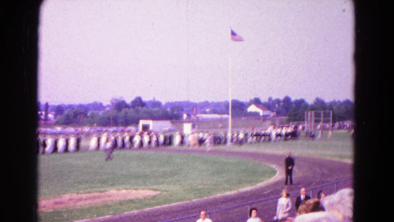Wide 1966 Hagerstown view of people standing in formation on a track field while spectators watch from the stands.
