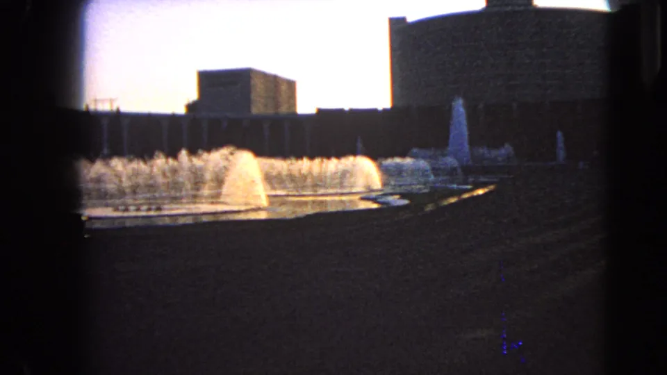 1966 Las Vegas fountain scene with multiple water jets, a curved basin edge, and dark building silhouettes.