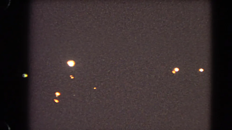 Dark 1966 Las Vegas home-movie frame with bright streetlights scattered across a grainy, low-exposure night scene.
