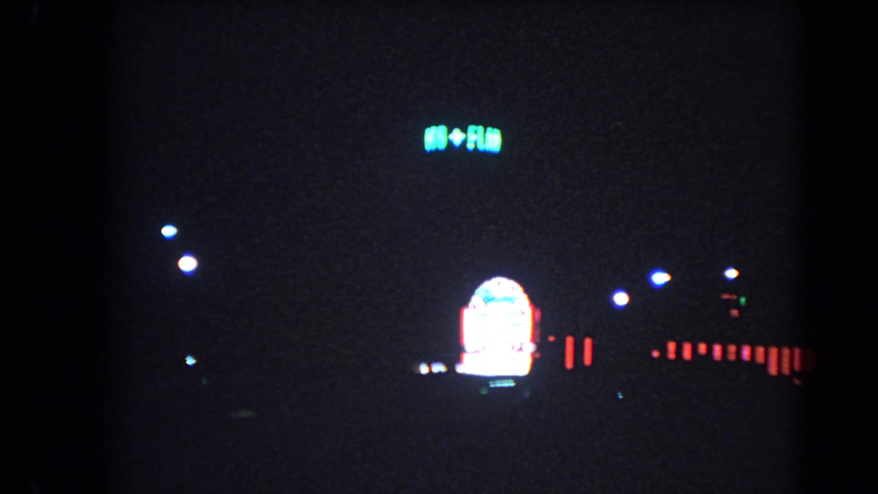 Distant Las Vegas neon and small roadside lights appear in a dark 1966 night street frame.