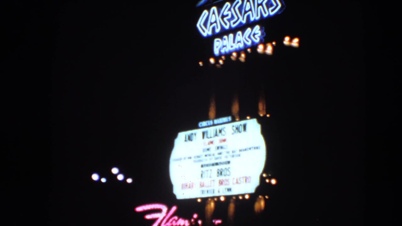 1966 Las Vegas night frame showing Caesars Palace neon and a marquee advertising the Andy Williams Show.