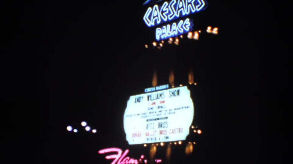 1966 Las Vegas night frame showing Caesars Palace neon and a marquee advertising the Andy Williams Show.