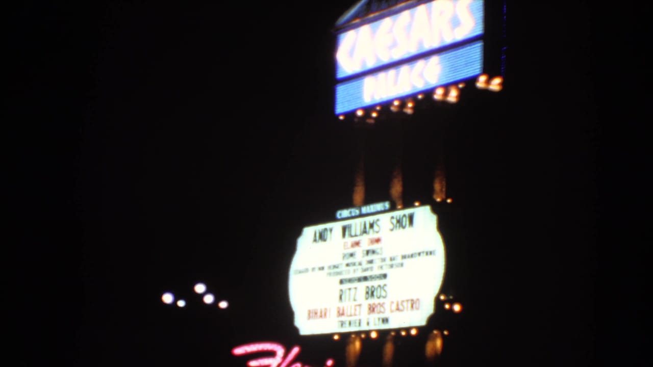 Bright Caesars Palace sign above a lit marquee in the dark.
