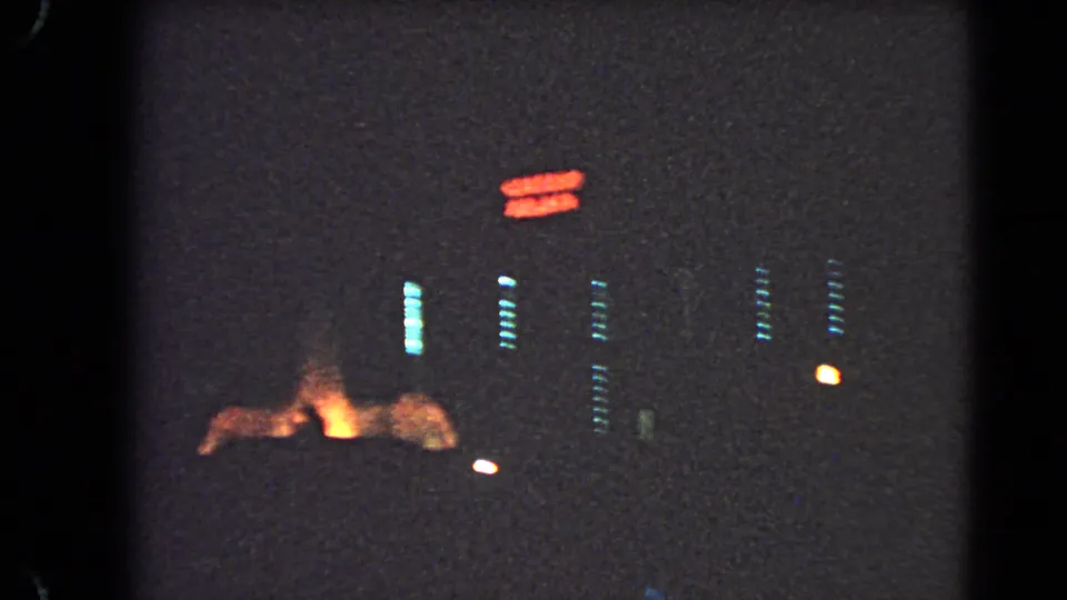 1966 Las Vegas night footage showing red neon signage above dim building lights and an orange glow near the lower street area.