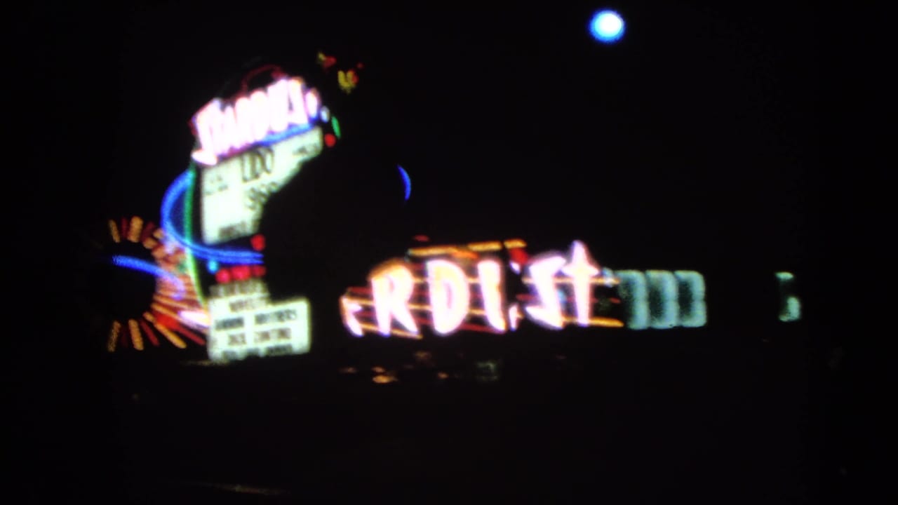 A 1966 Las Vegas frame shows the Gold Key Hotel sign near partial Stardust neon during a night drive.