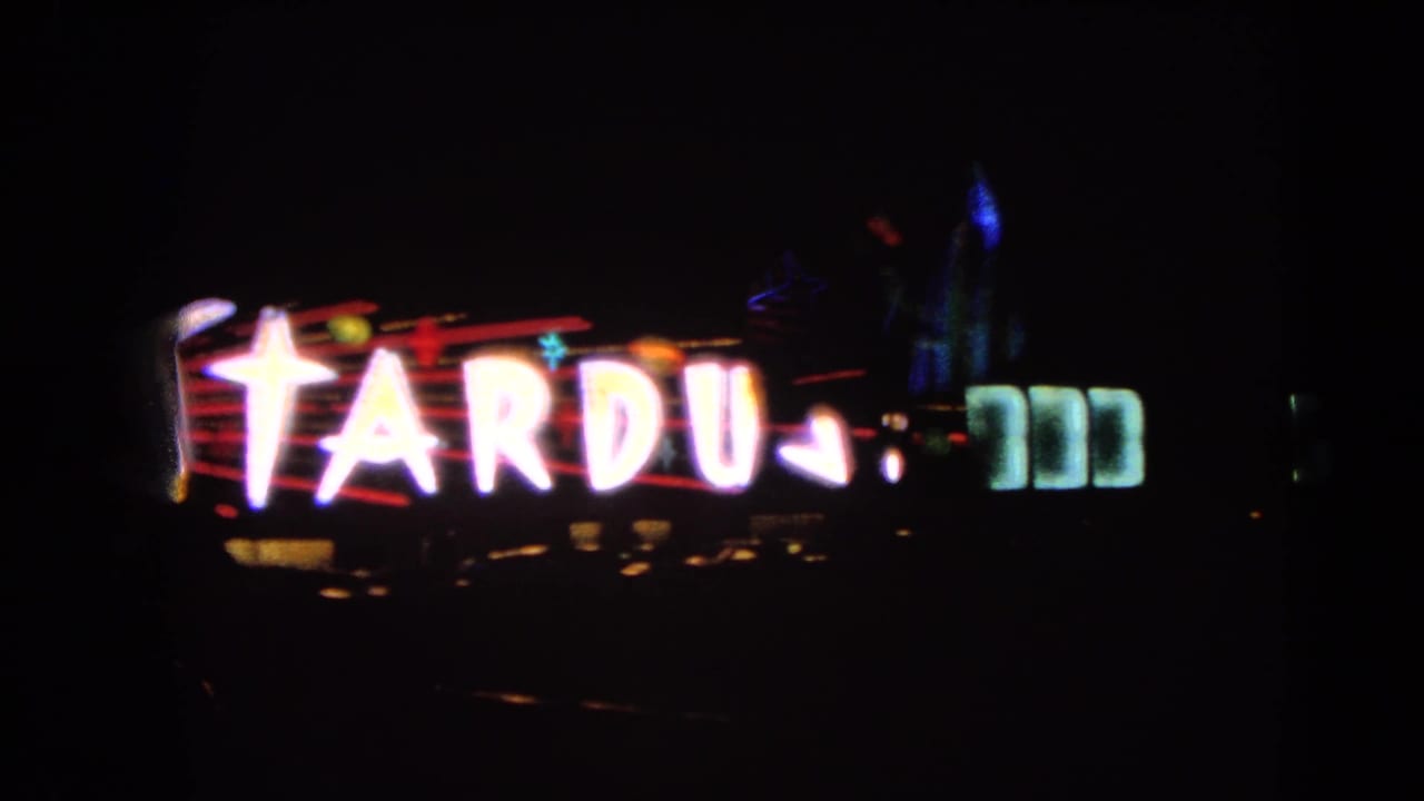Large Stardust neon letters dominate this 1966 Las Vegas night-drive frame, with smaller lights below.