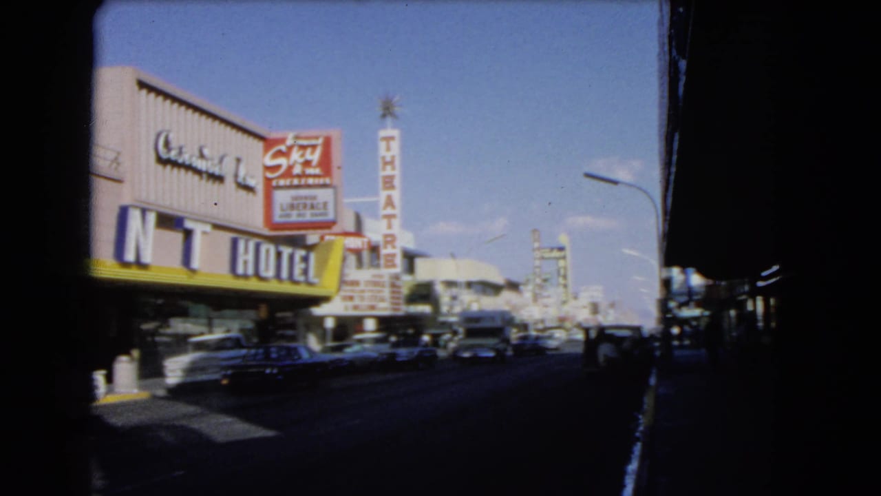 Mint Hotel frontage and theatre sign above a busy street with several cars in view.