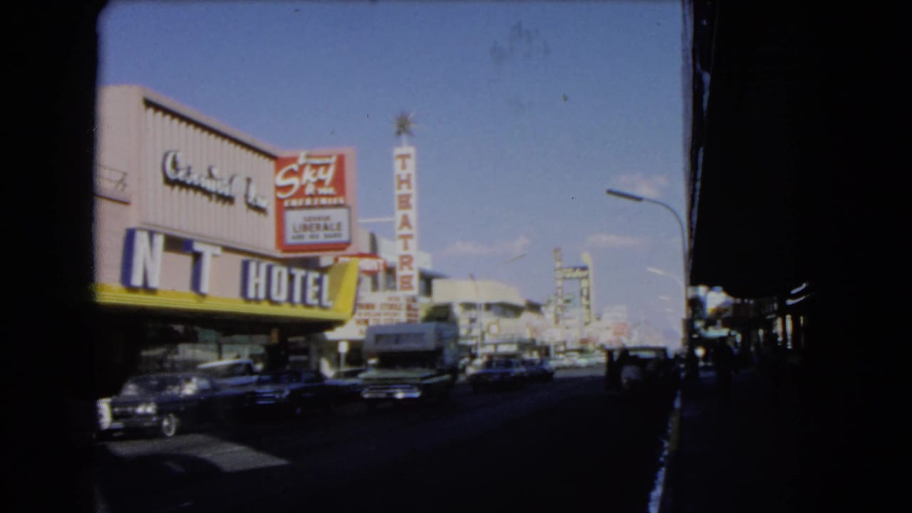 Las Vegas street view with Central Inn Hotel, Sky Theatre sign, parked cars, and blue sky.