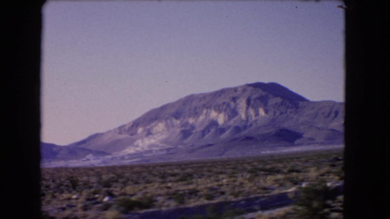 1966 Las Vegas, Nevada 8mm still showing an arid plain, scattered shrubs, and a prominent mountain under washed color.