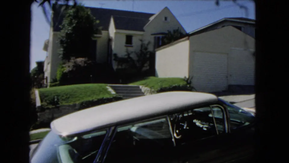 A 1966 Los Angeles residential exterior shows a suburban house, garage, lawn steps, and a parked midcentury car.