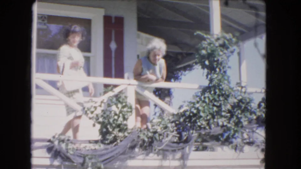 Two women are visible on a bright 1966 Los Angeles front porch, with the younger woman standing and the older woman near the railing.