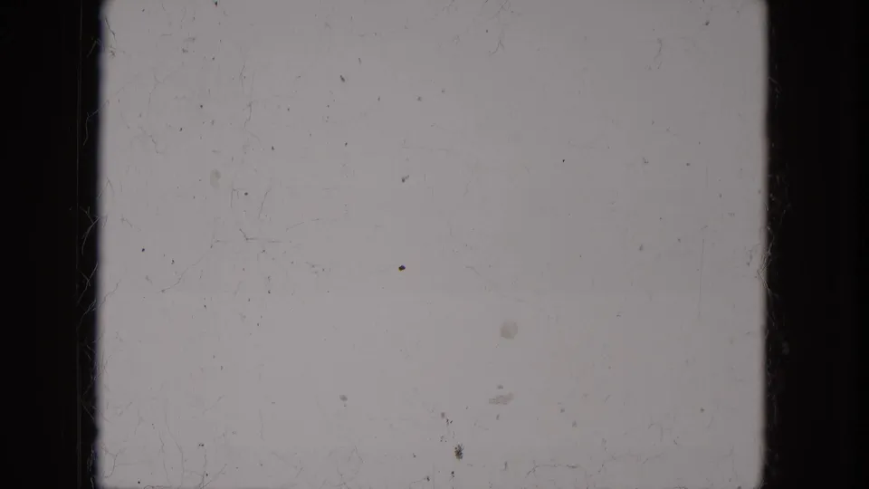 Pale 1966 8mm home-movie frame from Milwaukee metadata with dark film edge, scattered dust, faint scratches, and soft grain.