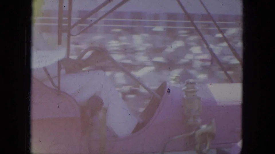 Faded 1966 Milwaukee 8mm frame showing a pink antique-style open car beside railings with blurred surroundings.