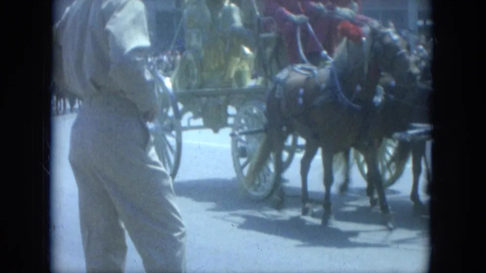 A horse-drawn circus wagon passes a street-side spectator in 1966 Milwaukee home-movie footage.