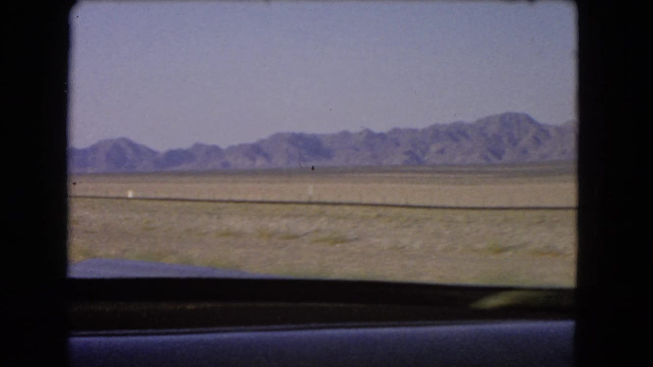 Distant mountains and open Nevada desert remain visible through the car window near the end of the 1966 8mm clip.