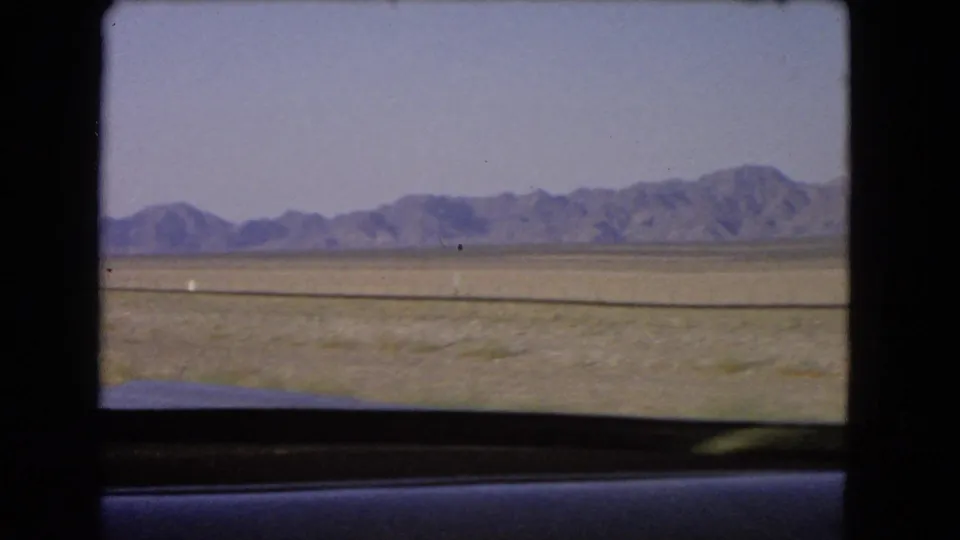 Distant mountains and open Nevada desert remain visible through the car window near the end of the 1966 8mm clip.