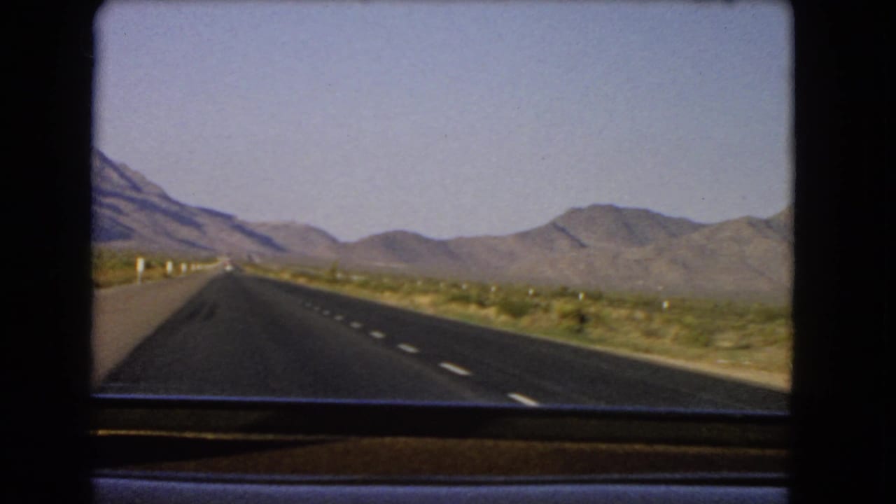 Open highway across desert terrain with mountains ahead.